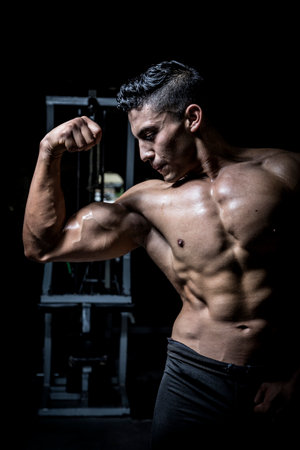 Young man exercising in dark and old gym