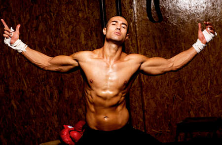 Young muscular man in gym doing exercise. Showing his muscles.