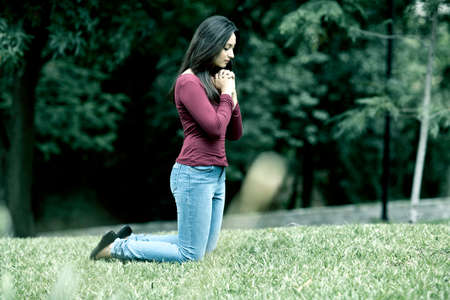 Woman hands praying Outdoors in the forest desaturateの写真素材