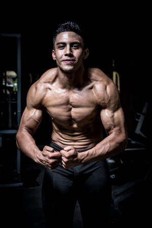 Young man exercising in dark and old gymの写真素材