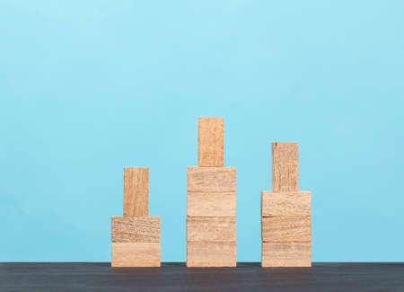 Wooden block stacking as step stair on blue background, Ladder of success in business growth...