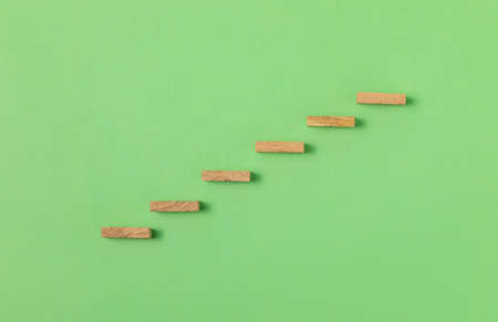 Wooden block stacking as step stair on green background, Ladder of success in business growth concept, copy spaceの写真素材
