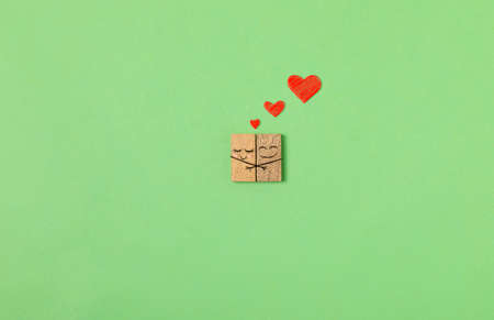 Man and woman wooden chips in love concep with cute cartoon animations on green background.の写真素材