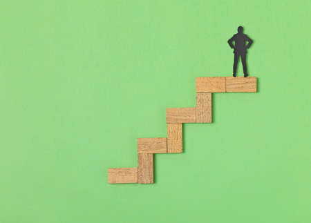 Wooden block stacking as step stair on green background, Ladder of success in business growth...