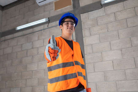 Young proud electrician fixing the electrical system of a house looking ath the camera
