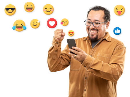 Laughing 40s man reacting to post with emojis on his smartphone.の写真素材