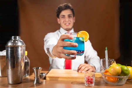 Young attractive bartender serving a cocktail in the bar  of a barの写真素材