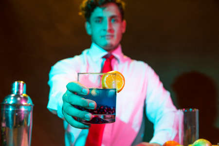 Young attractive bartender serving a cocktail in the bar  of a barの写真素材