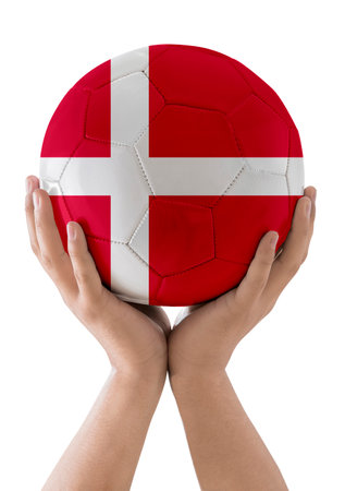 Man's hands raising a soccer ball with the flag of the Denmark team as a trophy on a white background.の写真素材