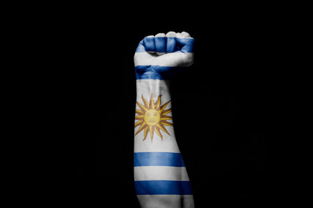 Strong man's hand in battle signal with Serbia flag on black background.の写真素材