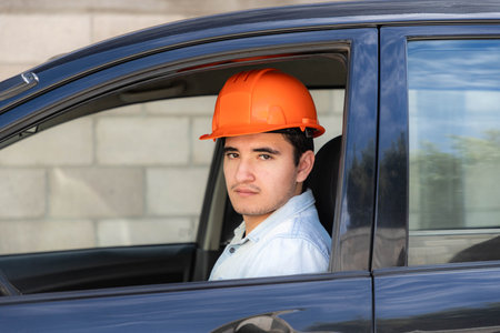 Young attractive latino Worker of the construction industry with protection orange helmet doing maintenance work in factory.の写真素材