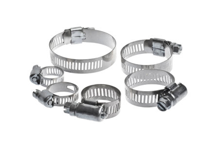 heap of metal clamps of different sizes for pipe on a white background arranged in different compositionsの写真素材