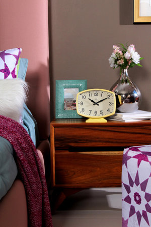 yellow clock with hands on bedroom dresserの写真素材