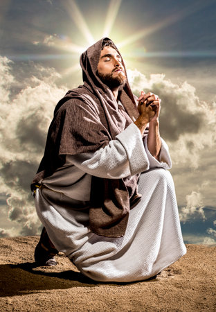 Jesus Christ praying to God in the dark black nightの写真素材