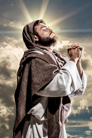 Jesus Christ praying to God in the dark black nightの写真素材