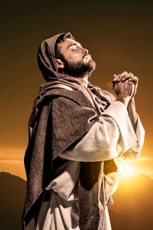 Jesus Christ praying to God in the dark black nightの写真素材