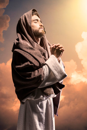Jesus Christ praying to God in the dark black nightの写真素材