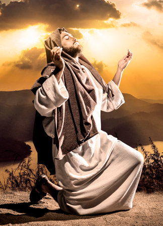Jesus Christ praying to God in the dark black nightの写真素材