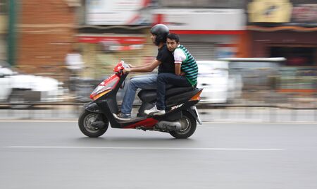Two Youngsters making a dash on their scooter in bangalore cityのeditorial素材