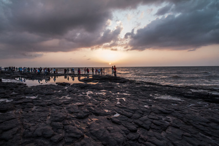 Monsoon sunset seen from a rocky beach of Mumbai, Indiaの写真素材