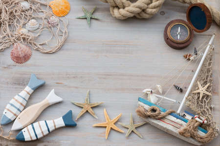 Frame of a boat, starfish and compass on a light gray background. Copy space.の写真素材