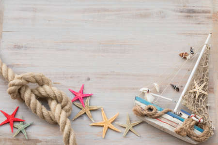 Miniature boat, starfish and seashells on a gray background. Time of sailing.の写真素材
