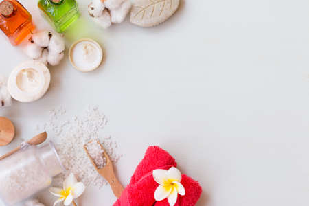 Spa set with a bath solt, comb, lotions and towels on white wooden background. Copy space.の写真素材