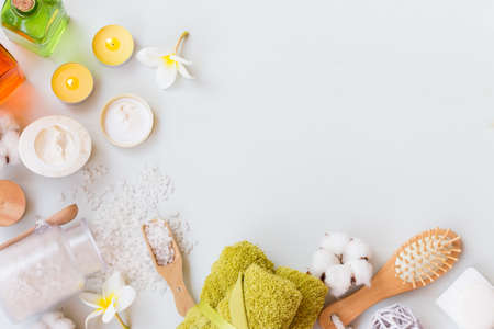 Wellness spa setting with natural soap, cream, candles and towels on a white wooden background with copy spaceの写真素材