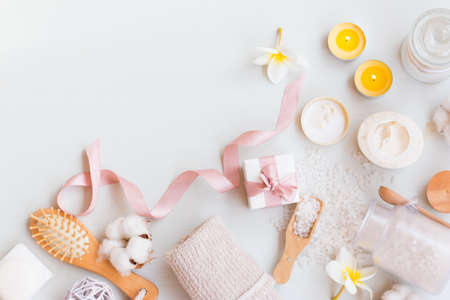 Top view on spa set with a natural soap, cream, candles and towels on a white wooden background with copy space.の写真素材