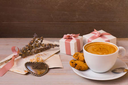 Wonderful morning on Valentines day with cup of coffee, gifts, decorative heart, flowers and letter from beloved.の写真素材