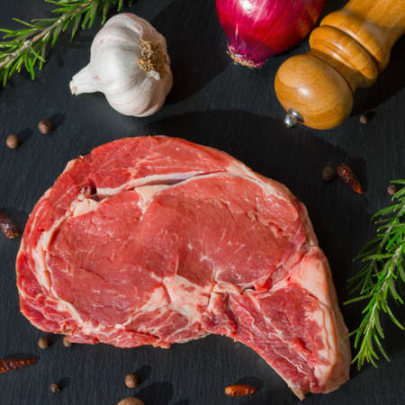 Juicy raw meat, beef entrecote on a black background, top view, close up.の写真素材