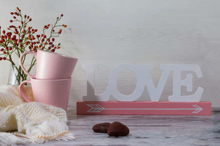 Two pink cups for tea and Jar for cookies and two cookies in form of heart lay on a light gray background.の写真素材