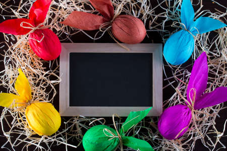 Frame of Easter eggs in the form of rabbit with blackboard to write the text. Holiday decorating.の写真素材