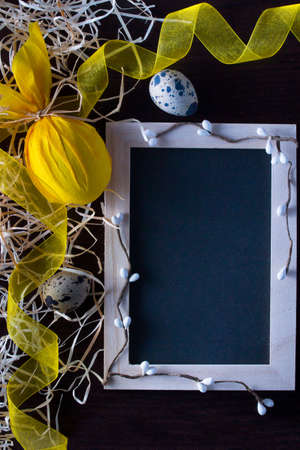 Easter eggs in form of rabbit with blackboard to write the text, willow branch, yellow ribbon and quail eggs . Holiday decorating.の写真素材