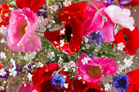 Bouquet of red and pink poppy and blue cornflower top view. Flowers backgroundの写真素材