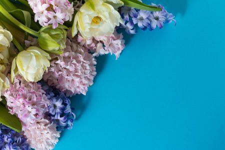 Bouquet of hyacinths and tulips on a blue background with copyspaceの写真素材