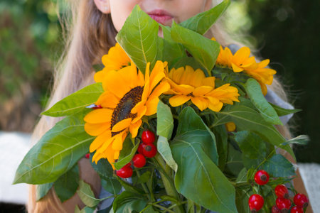 Bouquet of the yellow sunflowers in the hand of little girl.の写真素材