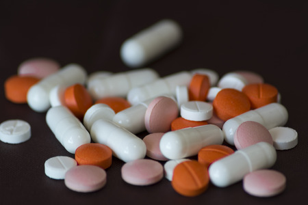 Group of pills on brown with great detail and contrasting colorsの写真素材