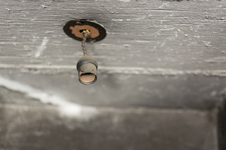 Socket spotlight, abandoned and broken. You can see the ceiling in low light and shadows.の写真素材