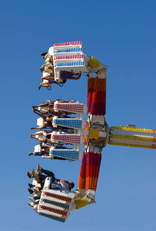 Fast ride at the carnival spins riders almost 360 degrees into the air, a lot of G force!の写真素材