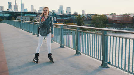 Young woman on rollerskates. Freedom concept. Roller skating on the urban bridge. High quality photo