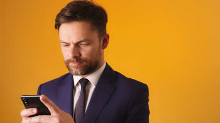 Managing a business with his smartphone. Bearded caucasian businessmen sending sms. High quality...