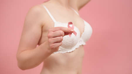 Close up. Woman in bra with pink ribbon, breast cancer survivor, pink october, awareness month. High quality photoの写真素材