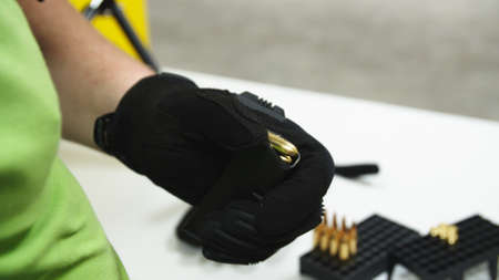 Adult loading an assault rifle at a shooting rangeの写真素材