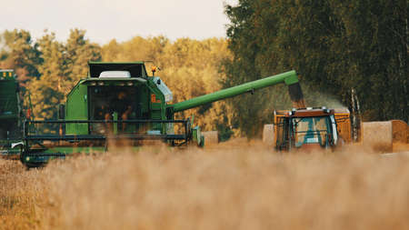 Warsaw, Poland 10.08.2020 Modern combine harvester thrasher and tractor with trail working on the...