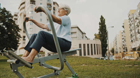 Wellbeing concept. Senior woman exercise using the equipment of an outdoor gym. High quality photoの写真素材
