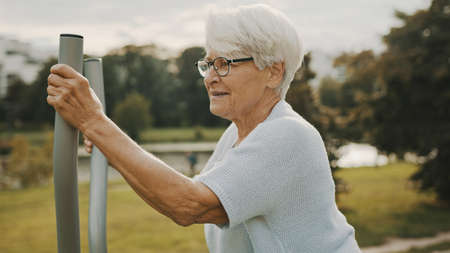 Old woman exercising in and outdoor gym. . High quality photoの写真素材