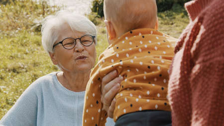Happy family concept. Mother, grandmother and baby having fun in nature. High quality photo