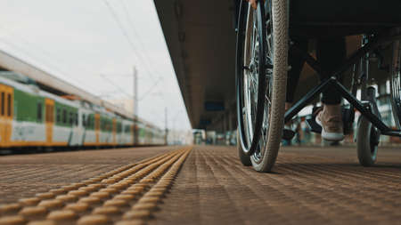 close up, young woman steering the wheel of the wheelchair. . High quality photo