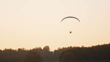 Silhouette of the Paramotor Tandem Gliding And Flying In The Air. Copy space High quality photoの写真素材